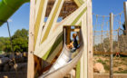 Child sliding down John Ball Zoo timber playground tower