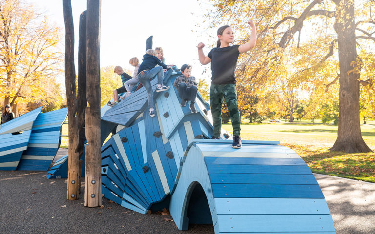 Denver playground blue dragon sculpture with kids at play