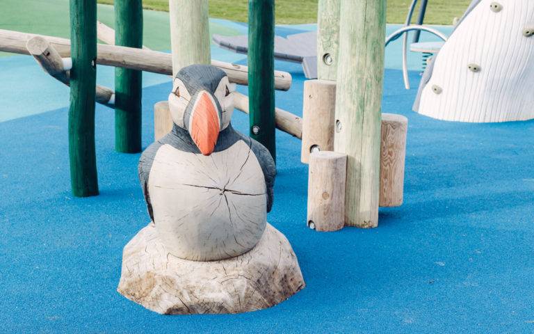 Fairwinds park puffin sculpture wood carving and poured in place rubber surfacing