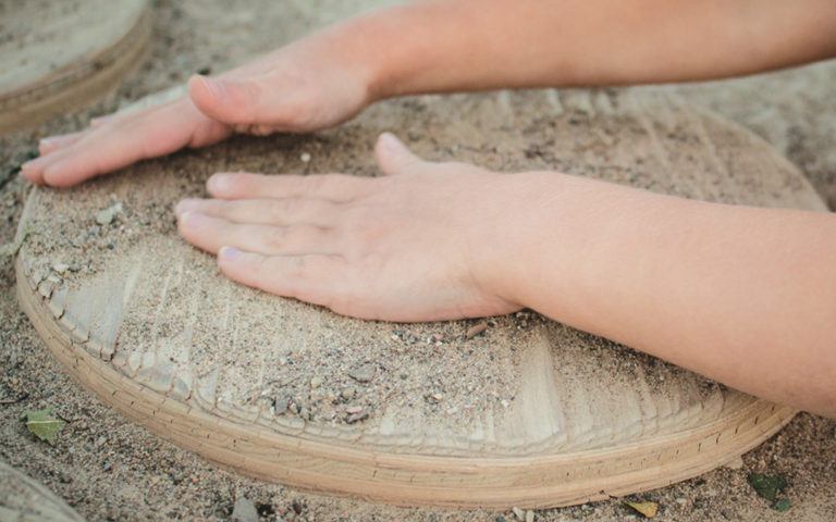 child hands play in sand at Empire Public School