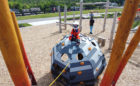 Child dressed as astronaut on meteor themed playground structure at Starfall Park