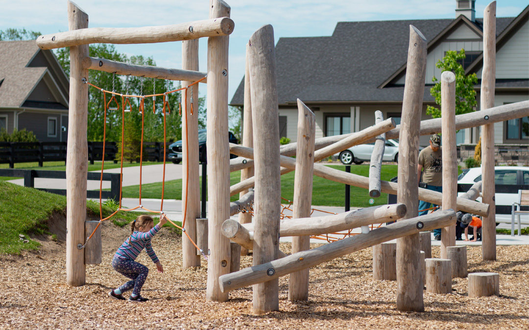 Natural wood playground with post and rope and nets plus log jam