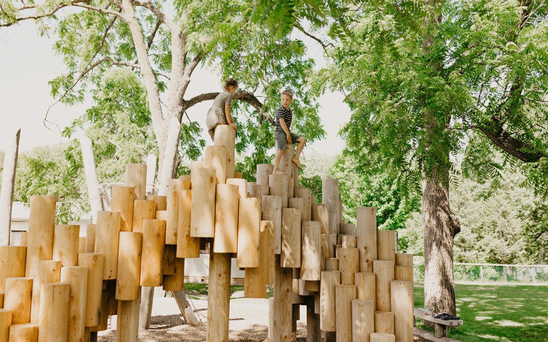 Girl and boy climb on Moku Yama playground structure and sculpture for public art